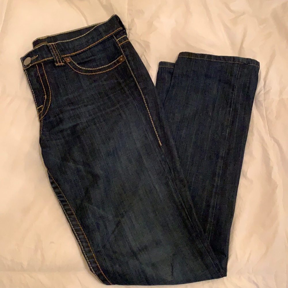 Dark wash jeans with contrast piping.